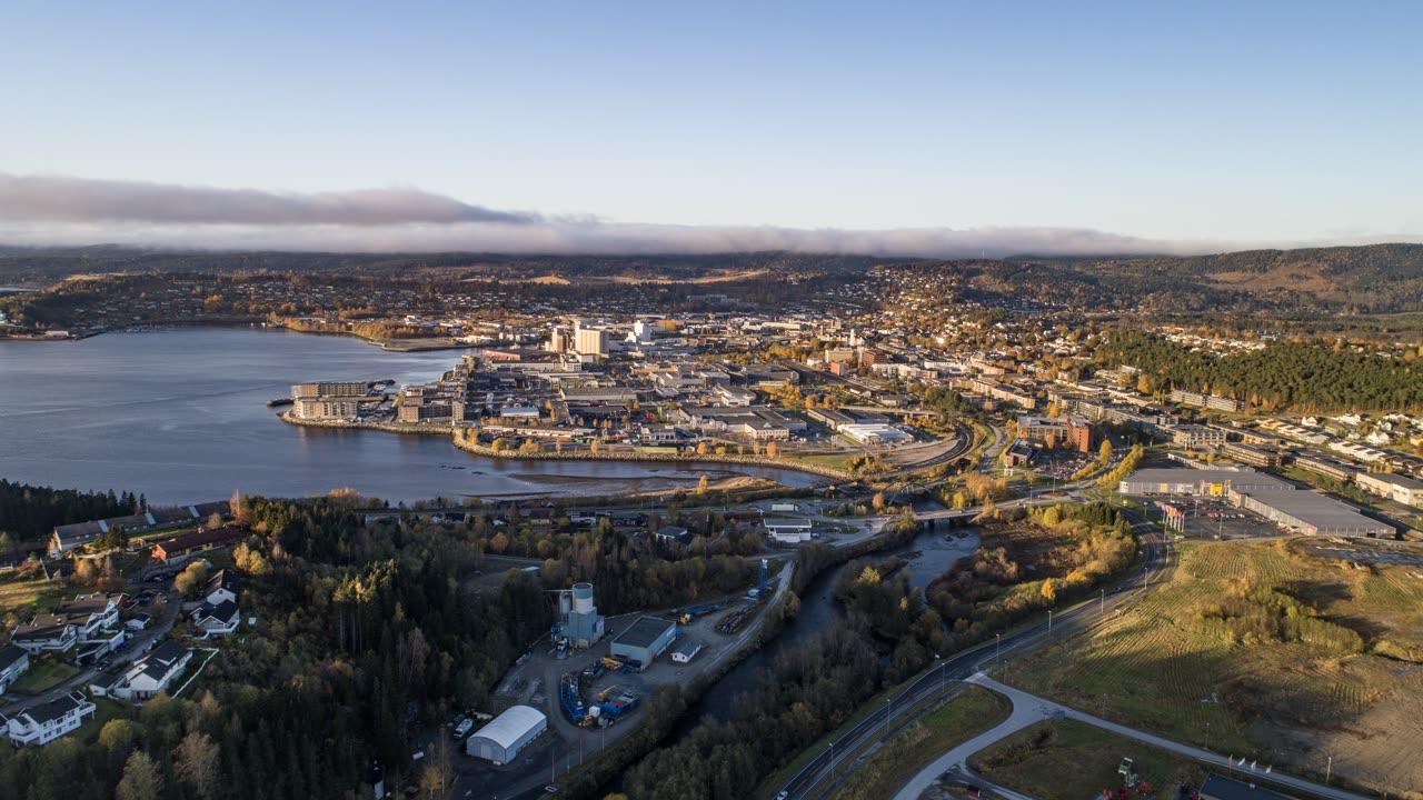 Flyfoto over Steinkjer sentrum i Trøndelag med bebyggelse, elv og omkringliggende landskap