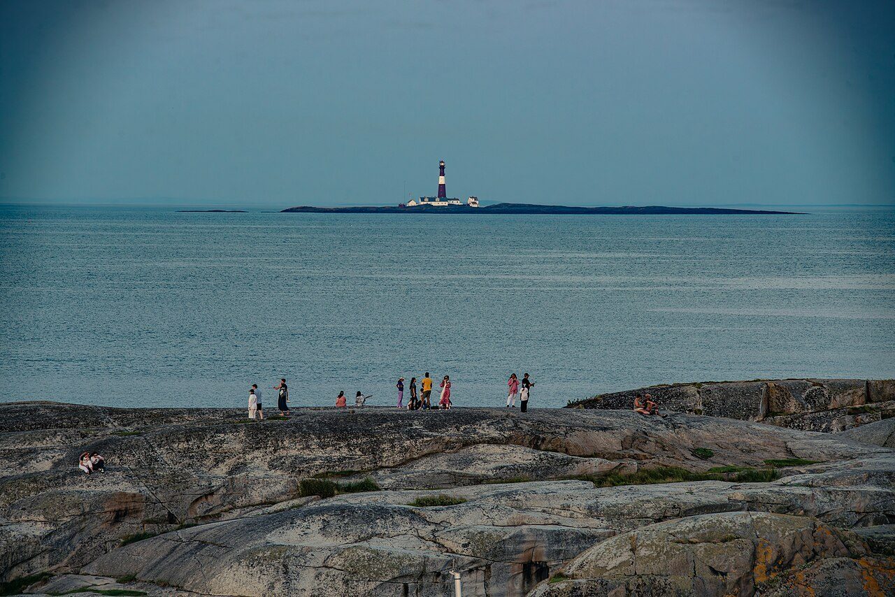 Vippefyret ved Verdens Ende på Tjøme i sommernatt, med svaberg og Oslofjorden i bakgrunnen