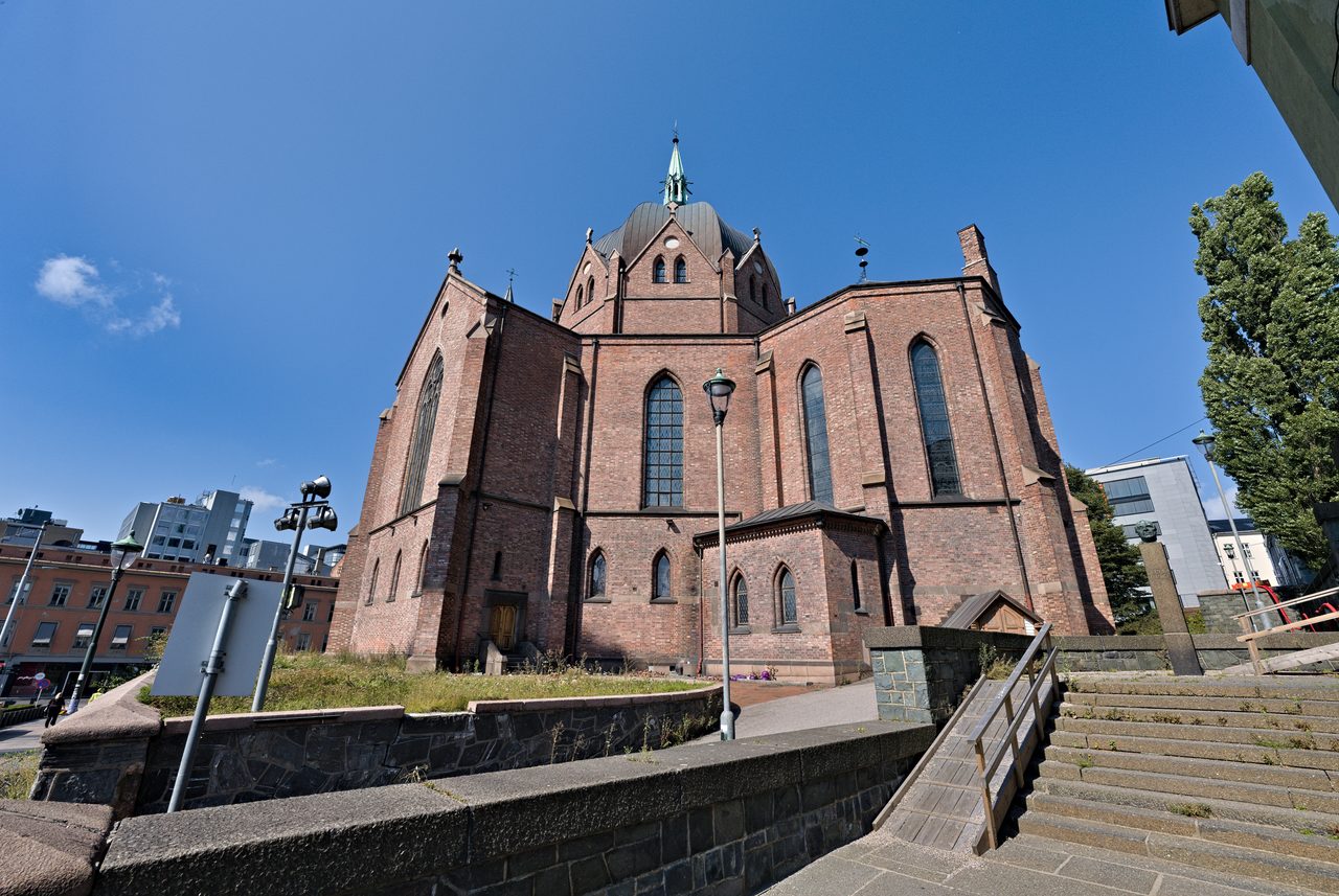 Trefoldighetskirken i Akersgata i Oslo, nygotisk teglkirke med kuppel og to tårn, sett utenfra i sol