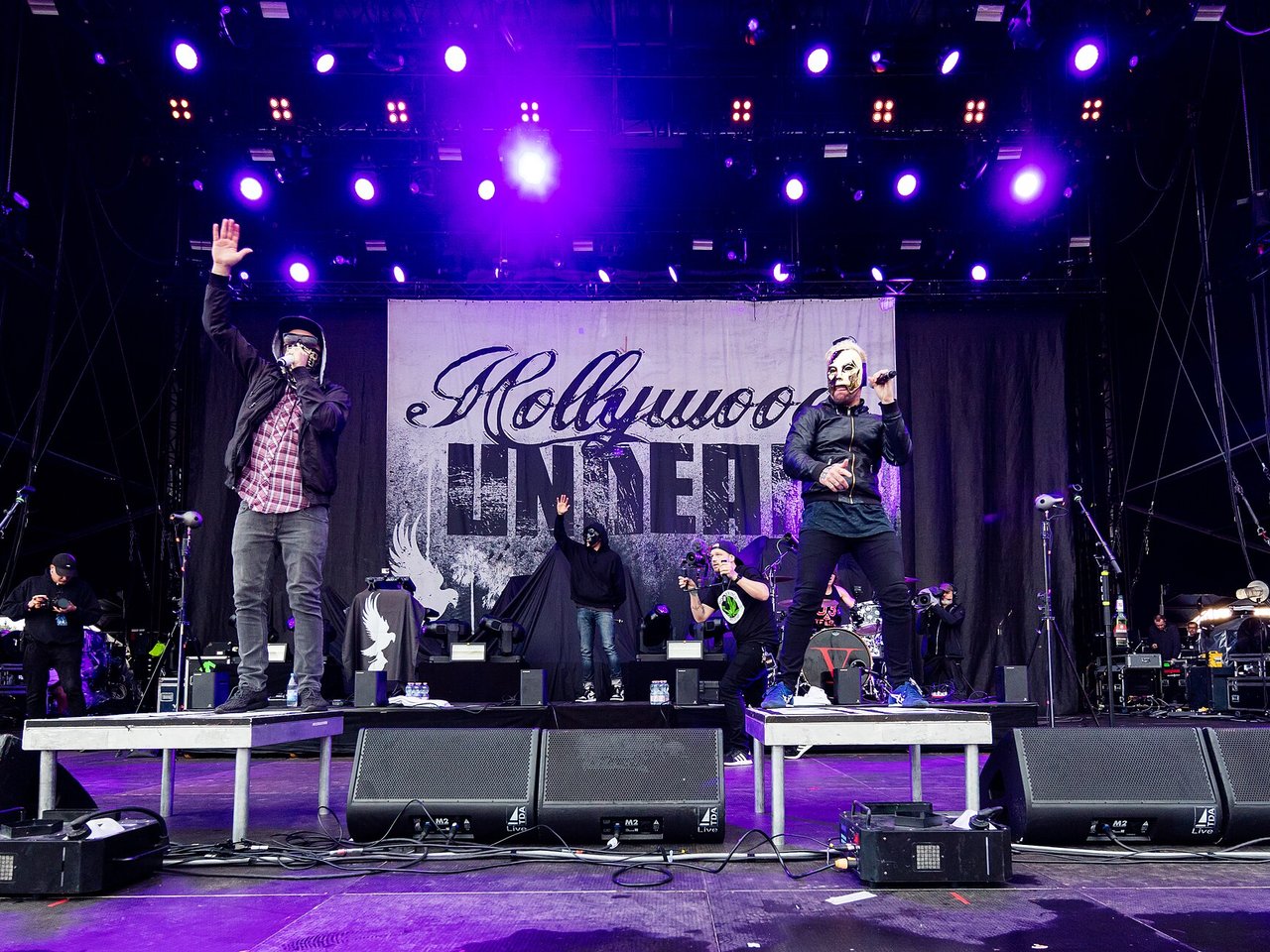 Hollywood Undead med masker på scenen under Rock am Ring i 2018, foran bandets eget banner